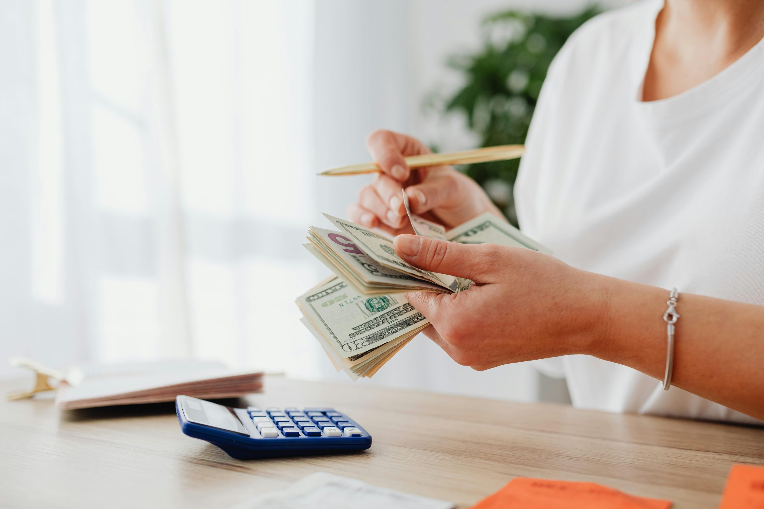 woman at a desk with a calculator, counting money