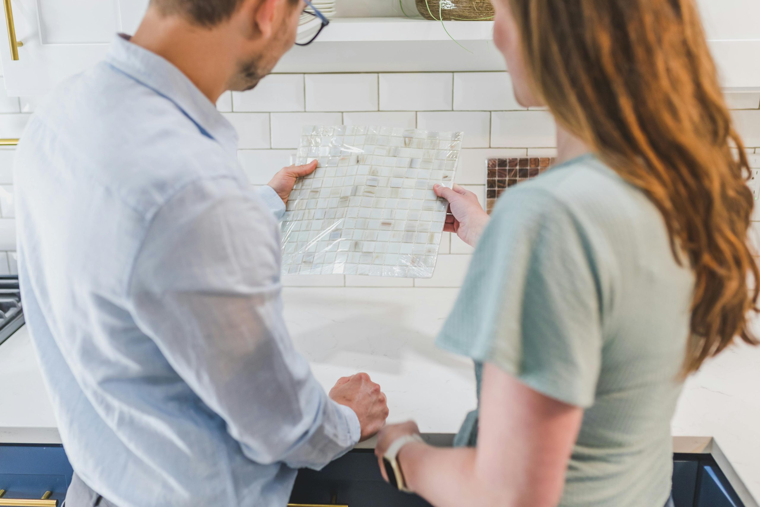 couple looking at tile designs for a kitchen renovation project